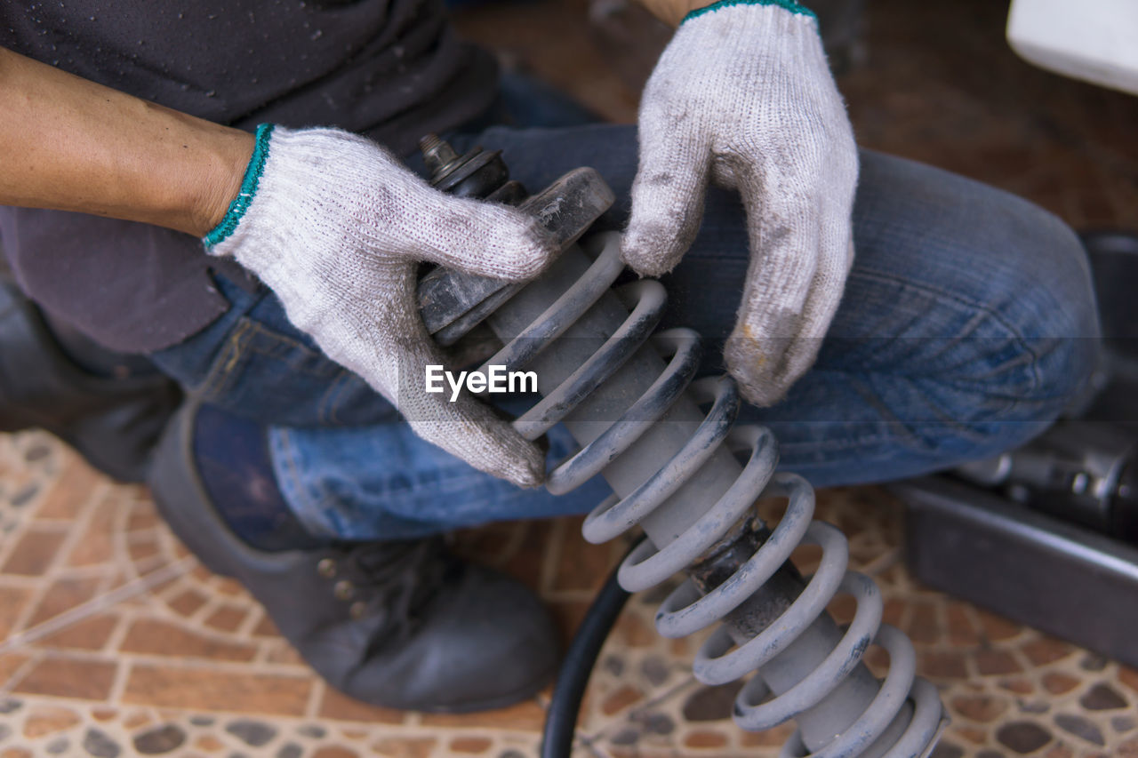 Low section of mechanic holding vehicle part