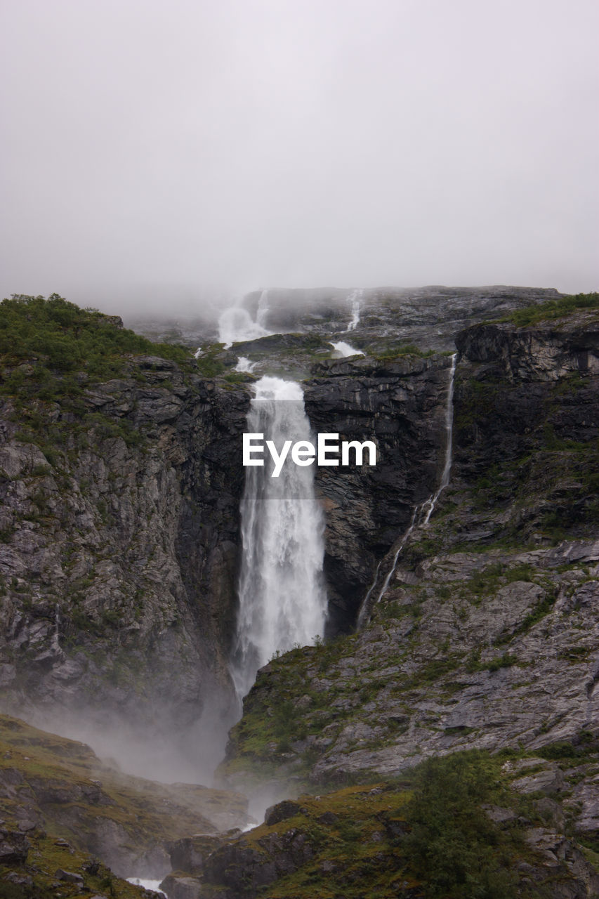 Scenic view of waterfall against sky