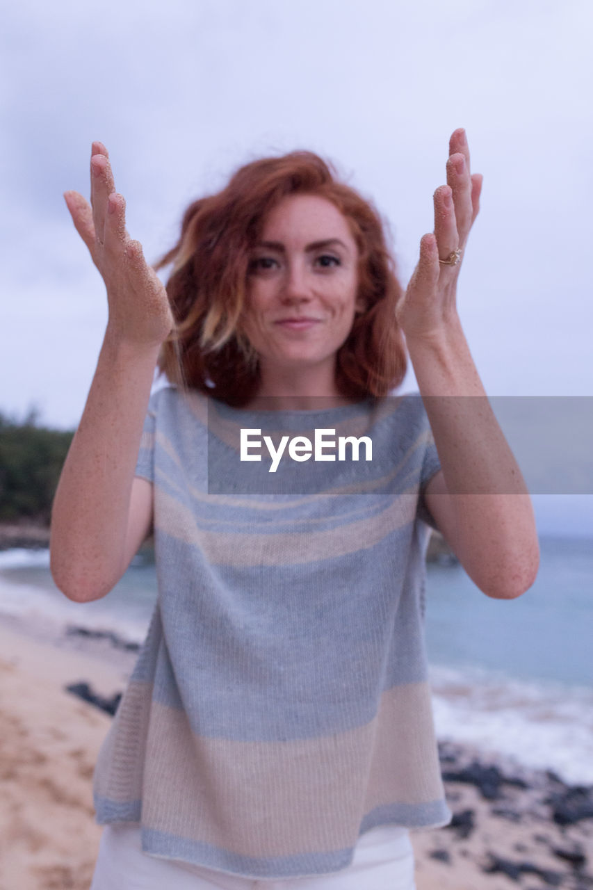 Woman playing with sand at beach