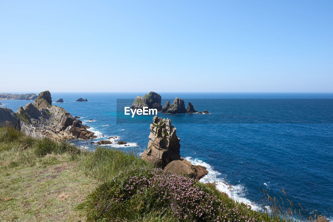 A beautiful view of cliffs surrounded by turquoise blue waters.