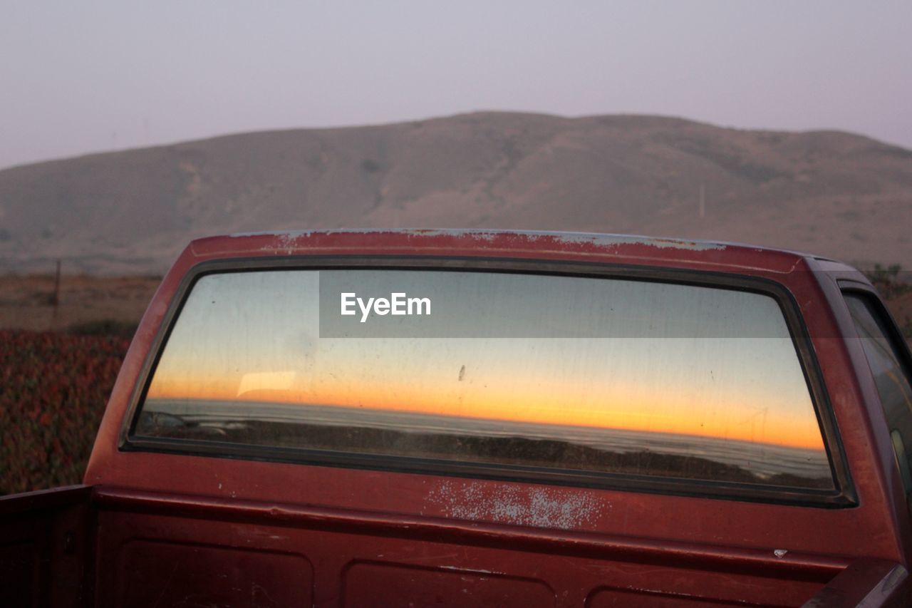 The sunset through the back window of a vintage car, in california. 
