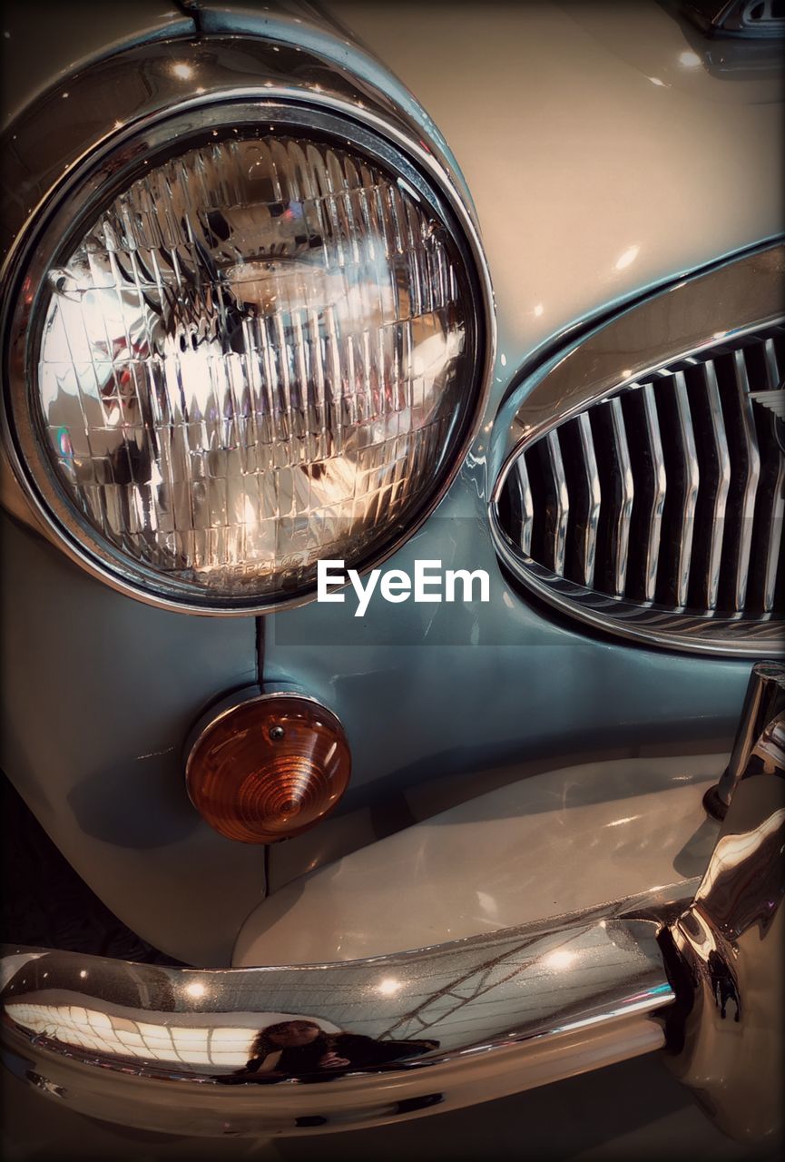 car, light, automobile, vehicle, headlight, mode of transportation, transportation, land vehicle, motor vehicle, retro styled, headlamp, lighting equipment, metal, wheel, vintage car, automotive exterior, no people, indoors, close-up, reflection