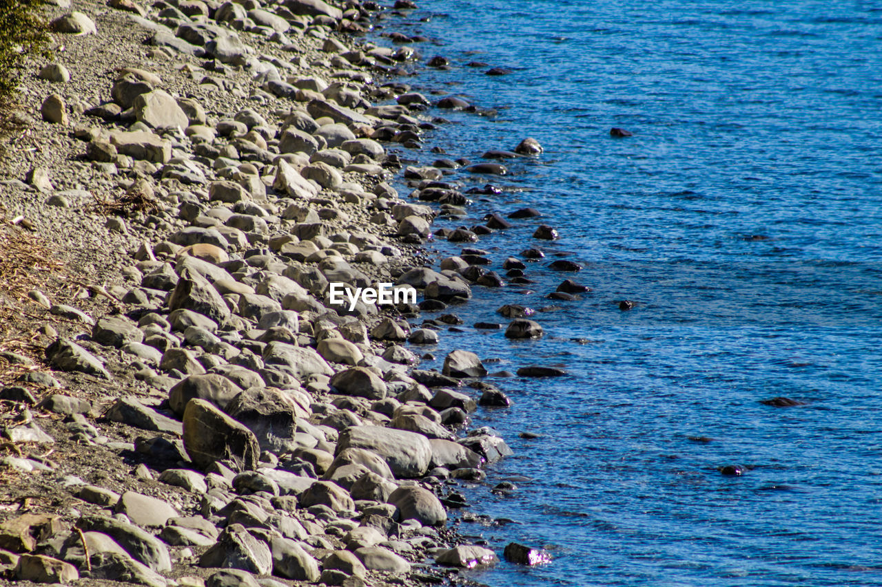 HIGH ANGLE VIEW OF GROUP OF PEOPLE ON ROCK