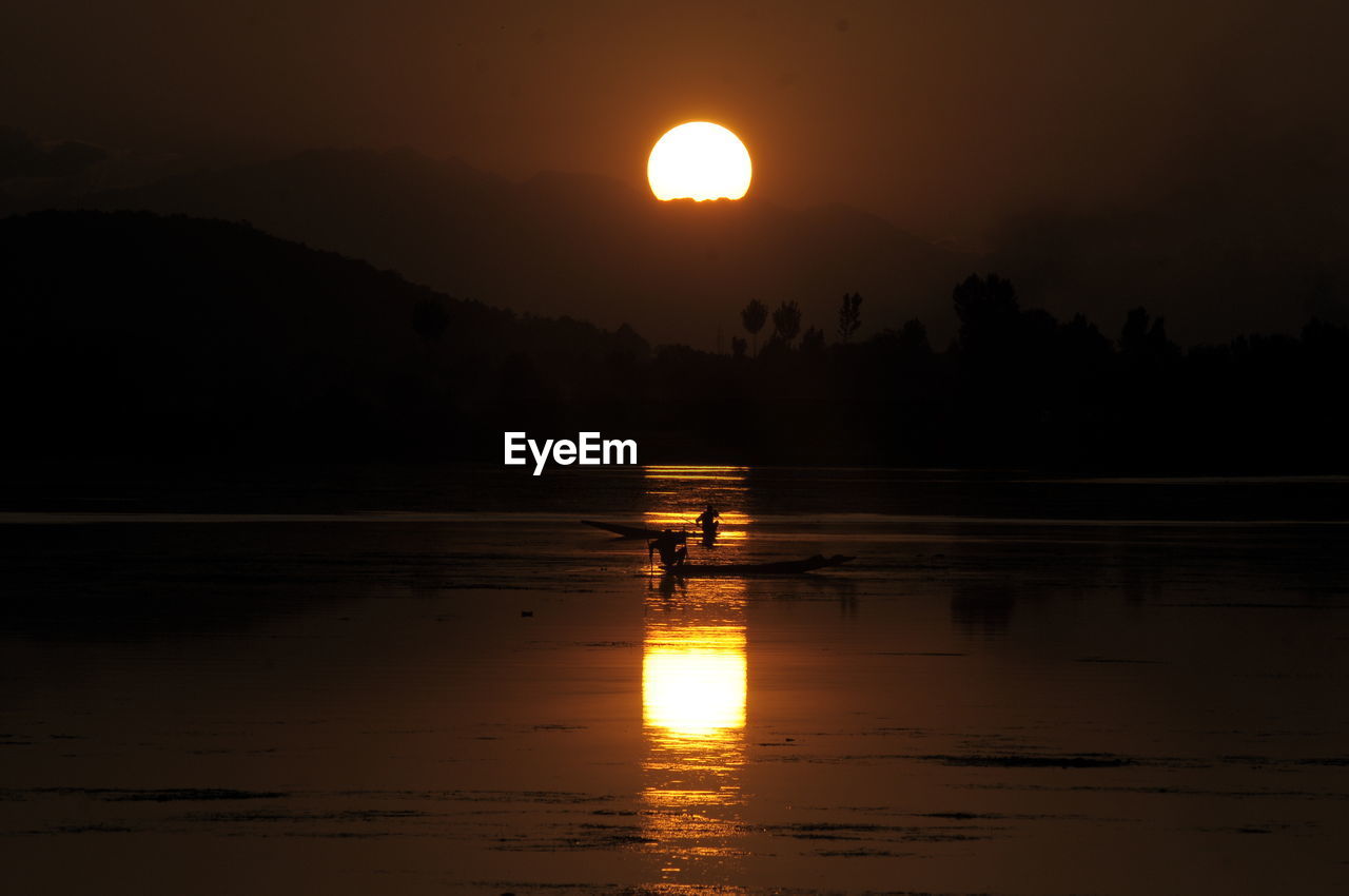 SCENIC VIEW OF LAKE AGAINST SKY AT SUNSET