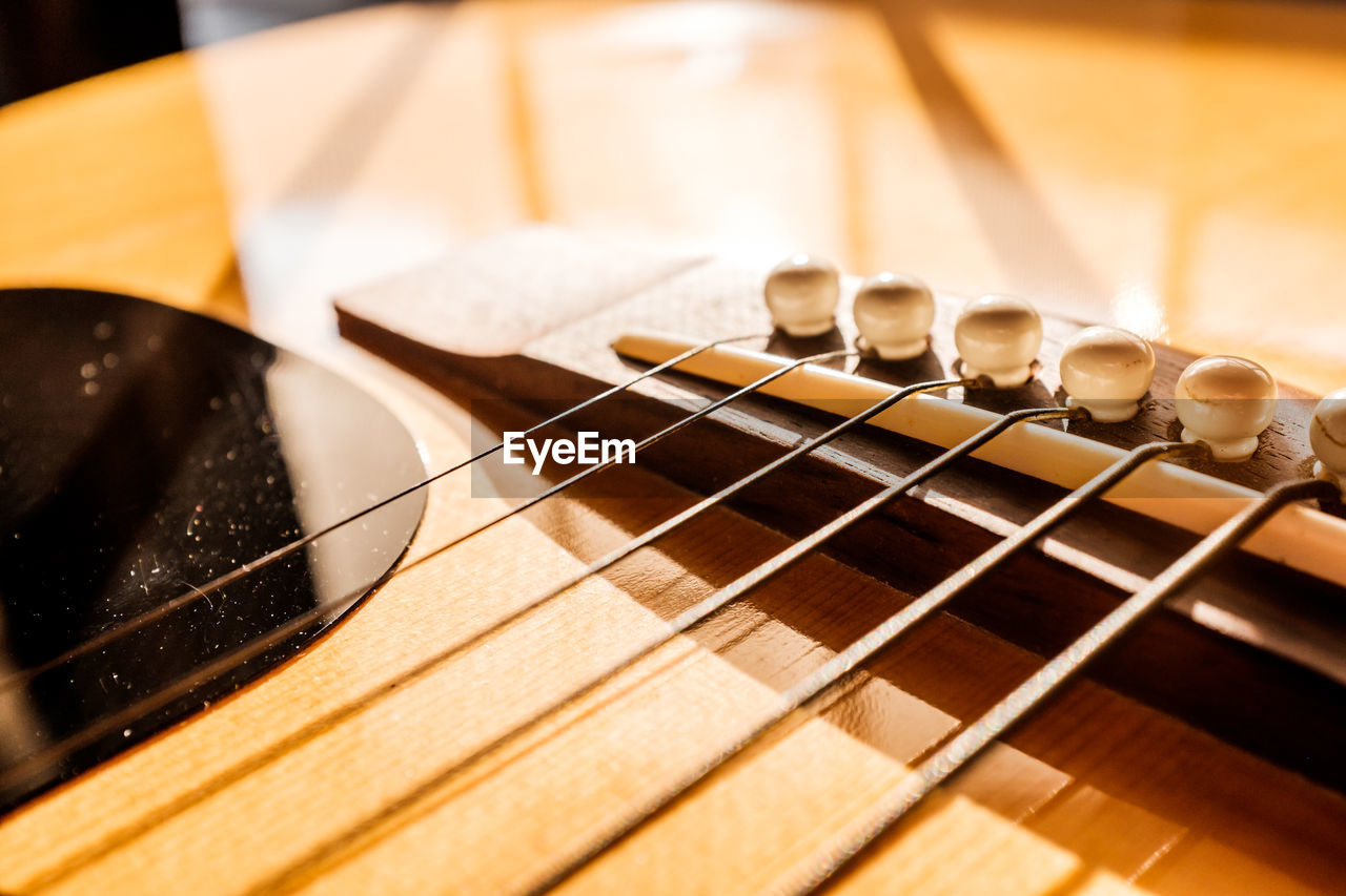 HIGH ANGLE VIEW OF GUITAR ON TABLE