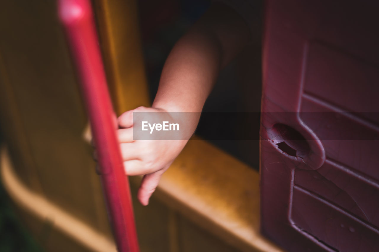 Cropped hand of toddler seen through window