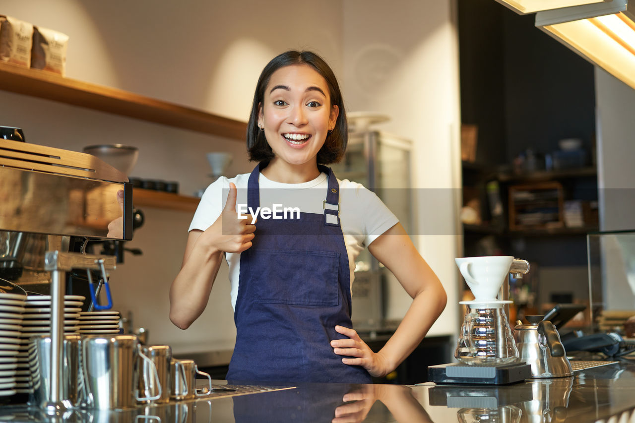 portrait of young woman using mobile phone while sitting on table