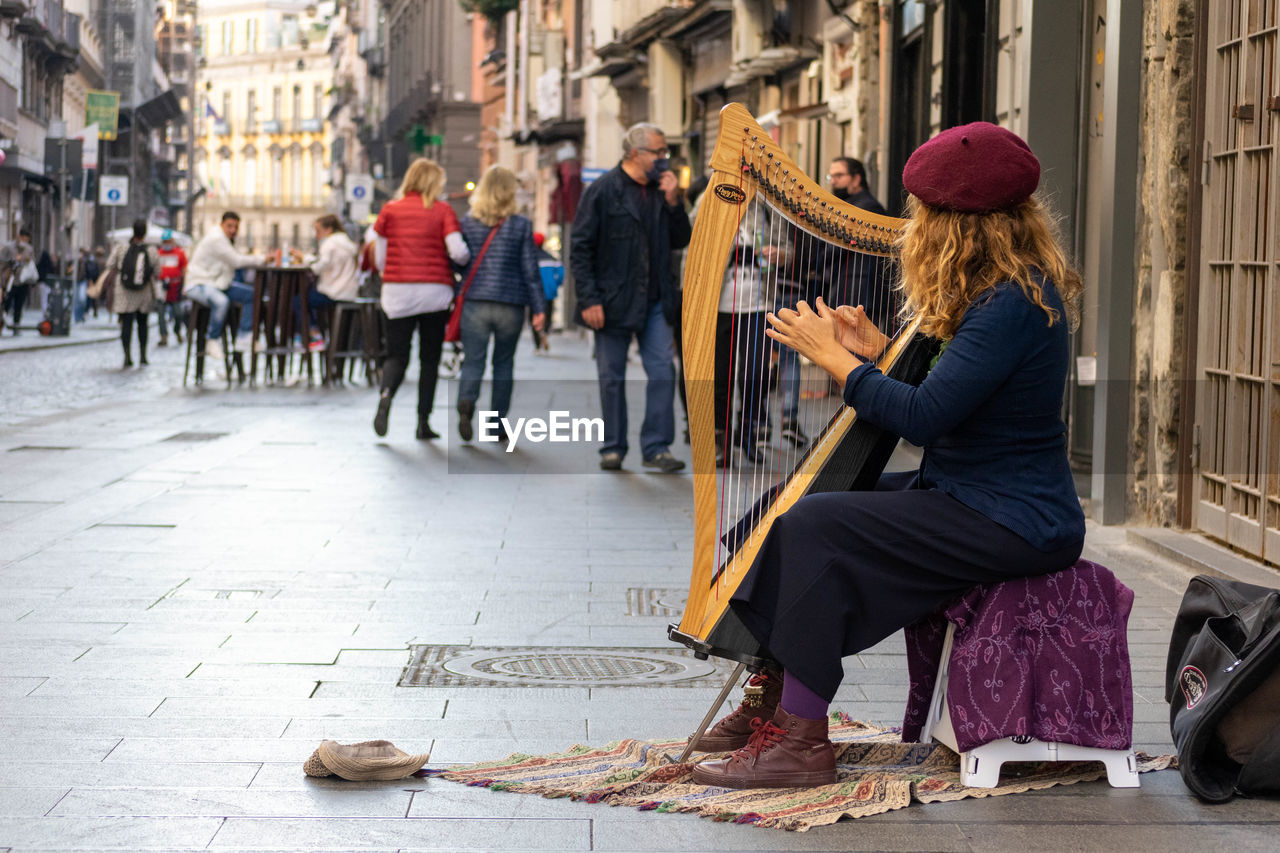 FULL LENGTH OF WOMAN SITTING ON STREET