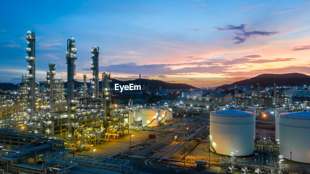 Aerial view oil and gas tank with oil refinery background at night, glitter lighting petrochemical.