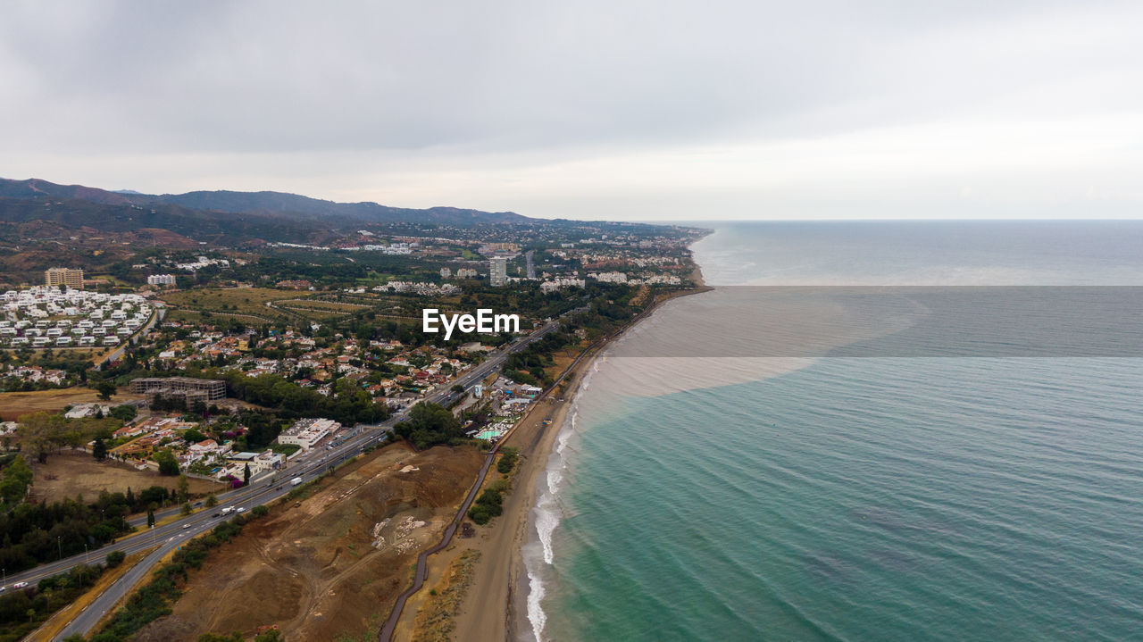 high angle view of city by sea against sky