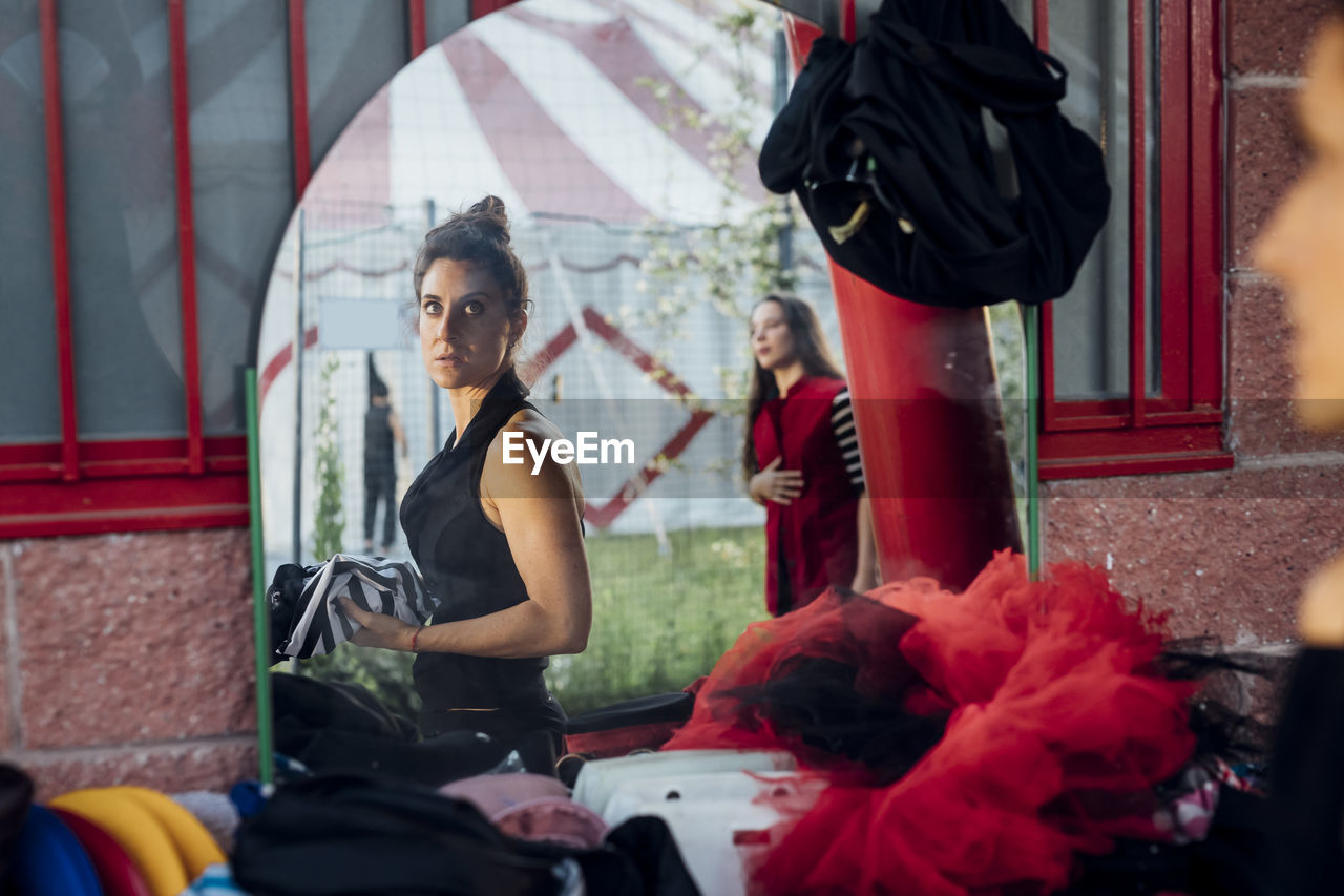 Reflection of female artists in mirror at circus tent