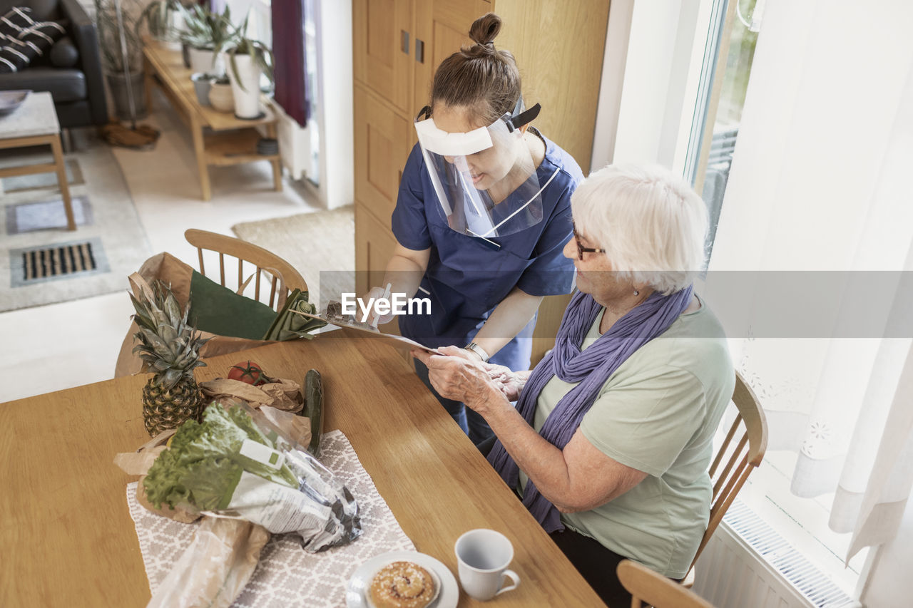 Home carer helping senior woman at home