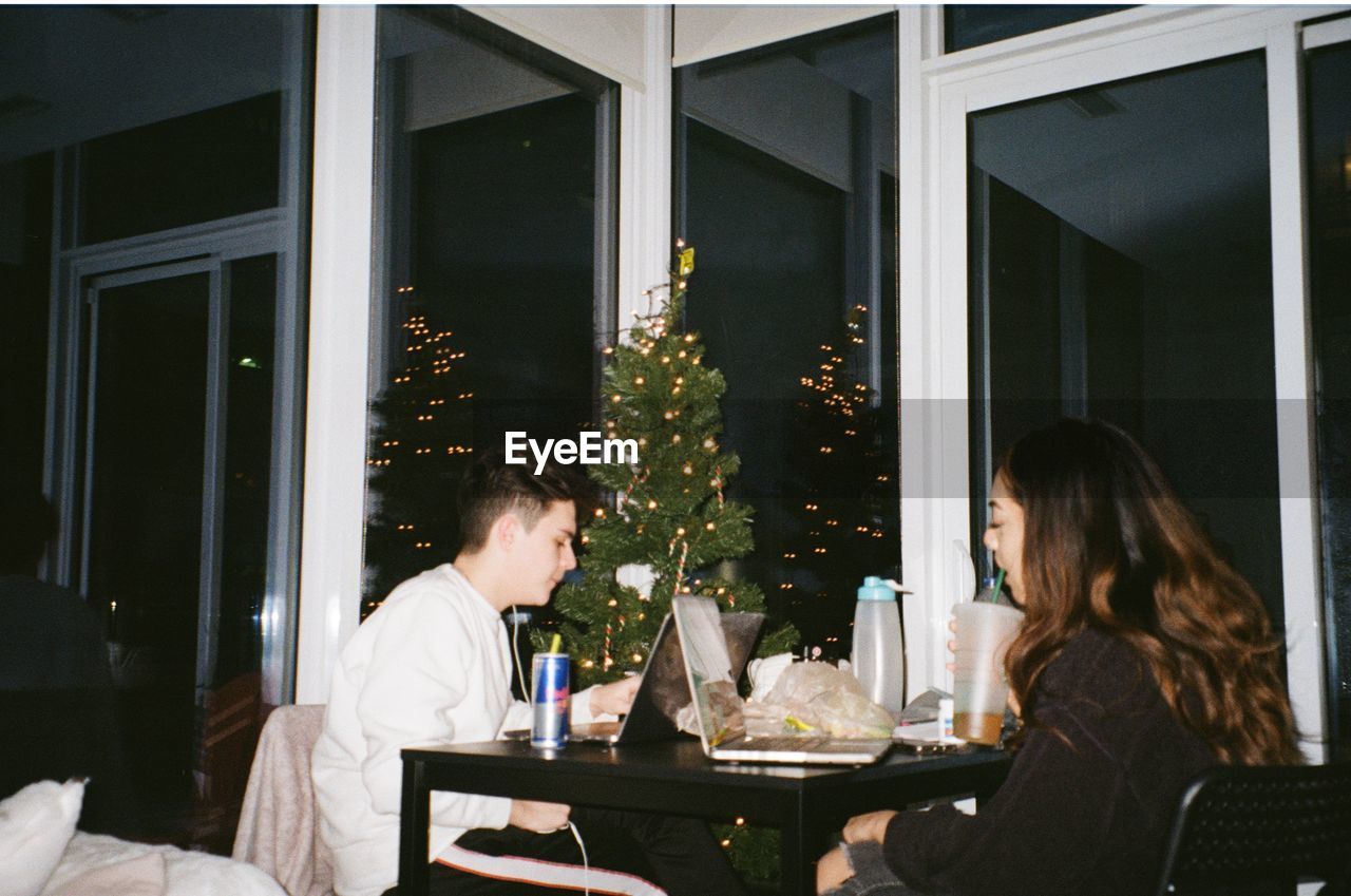 MAN AND WOMAN SITTING AT RESTAURANT TABLE AT NIGHT