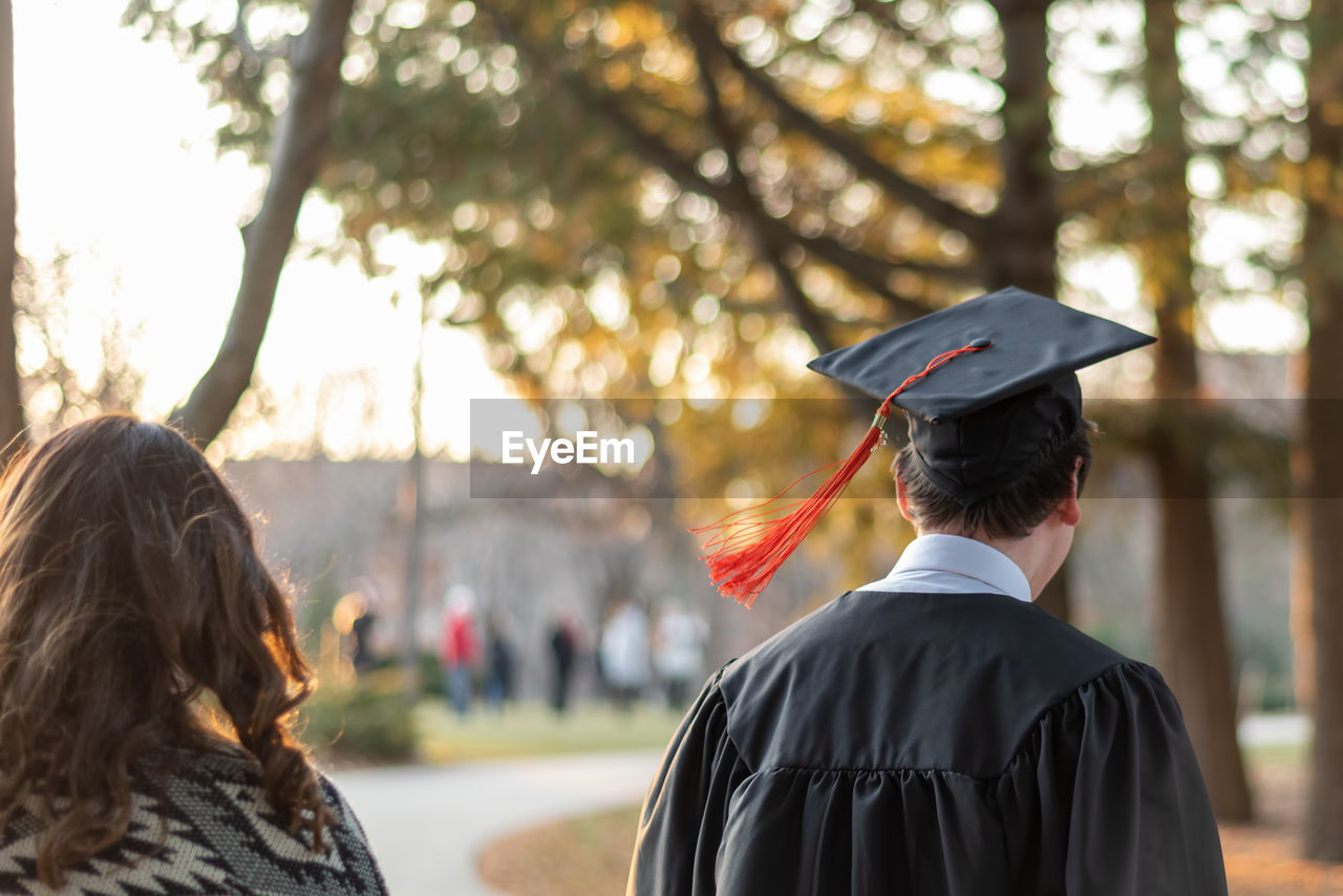 Rear view of students walking in city