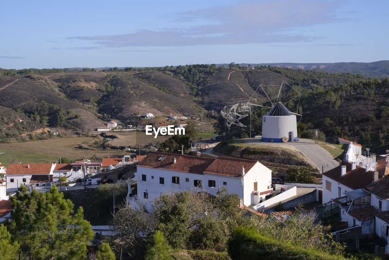 architecture, building exterior, built structure, building, house, town, village, residential district, high angle view, nature, plant, city, land, tree, aerial photography, no people, mountain, landscape, environment, roof, sky, travel destinations, outdoors, day, rural area, religion, scenics - nature, tourism, history, place of worship, the past, travel, community, vacation, rural scene, mountain range