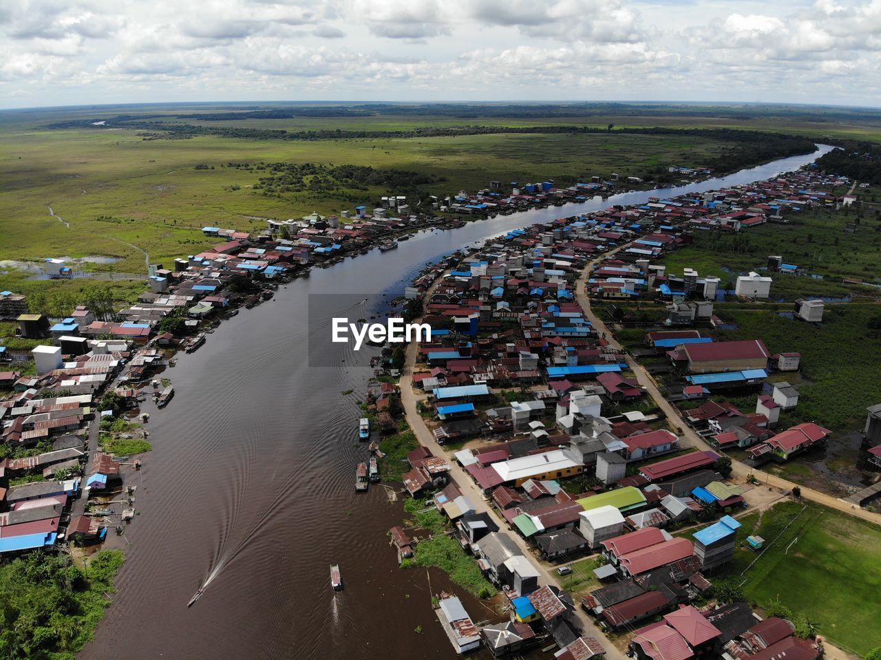 HIGH ANGLE VIEW OF CROWD BY BUILDINGS AGAINST SKY