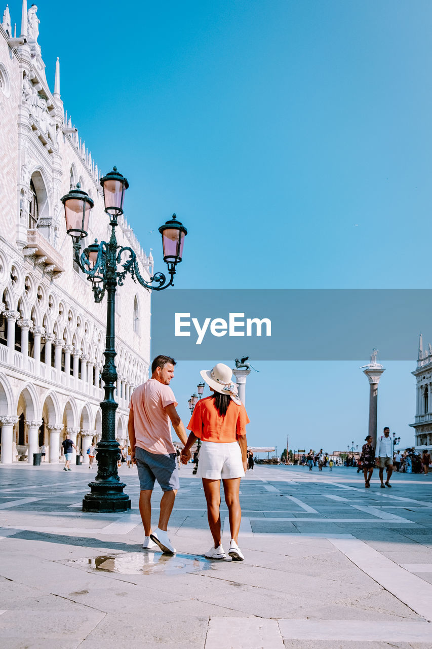 Couple on street against buildings in city