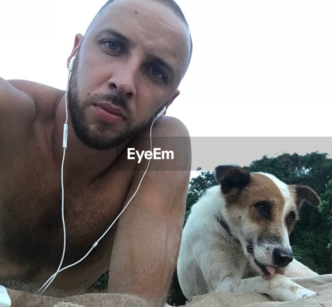 PORTRAIT OF SHIRTLESS MAN WITH DOG