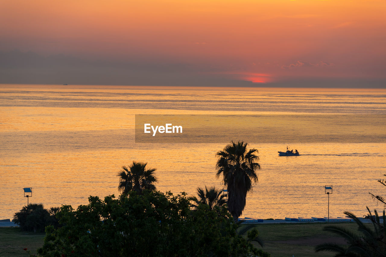 SCENIC VIEW OF SEA AGAINST SKY AT SUNSET