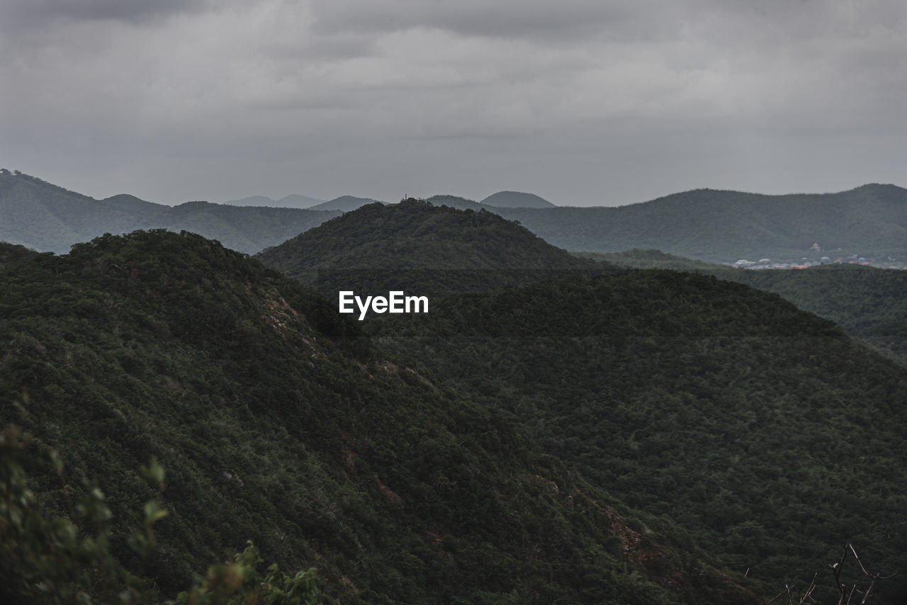 Scenic view of mountains against cloudy sky