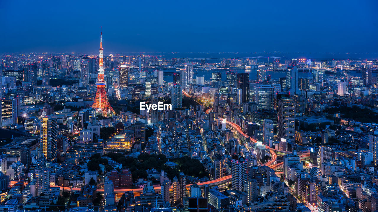 Aerial view of illuminated tokyo tower amidst buildings in city at night