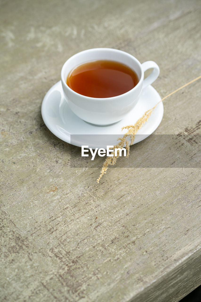 cup, food and drink, mug, tea, drink, hot drink, assam tea, tea cup, refreshment, da hong pao, crockery, saucer, coffee cup, darjeeling tea, high angle view, indoors, food, wellbeing, wood, oolong, no people, table, freshness, black tea, studio shot, coffee, porcelain, heat, afternoon tea, kitchen utensil, copy space, still life, relaxation, teabag