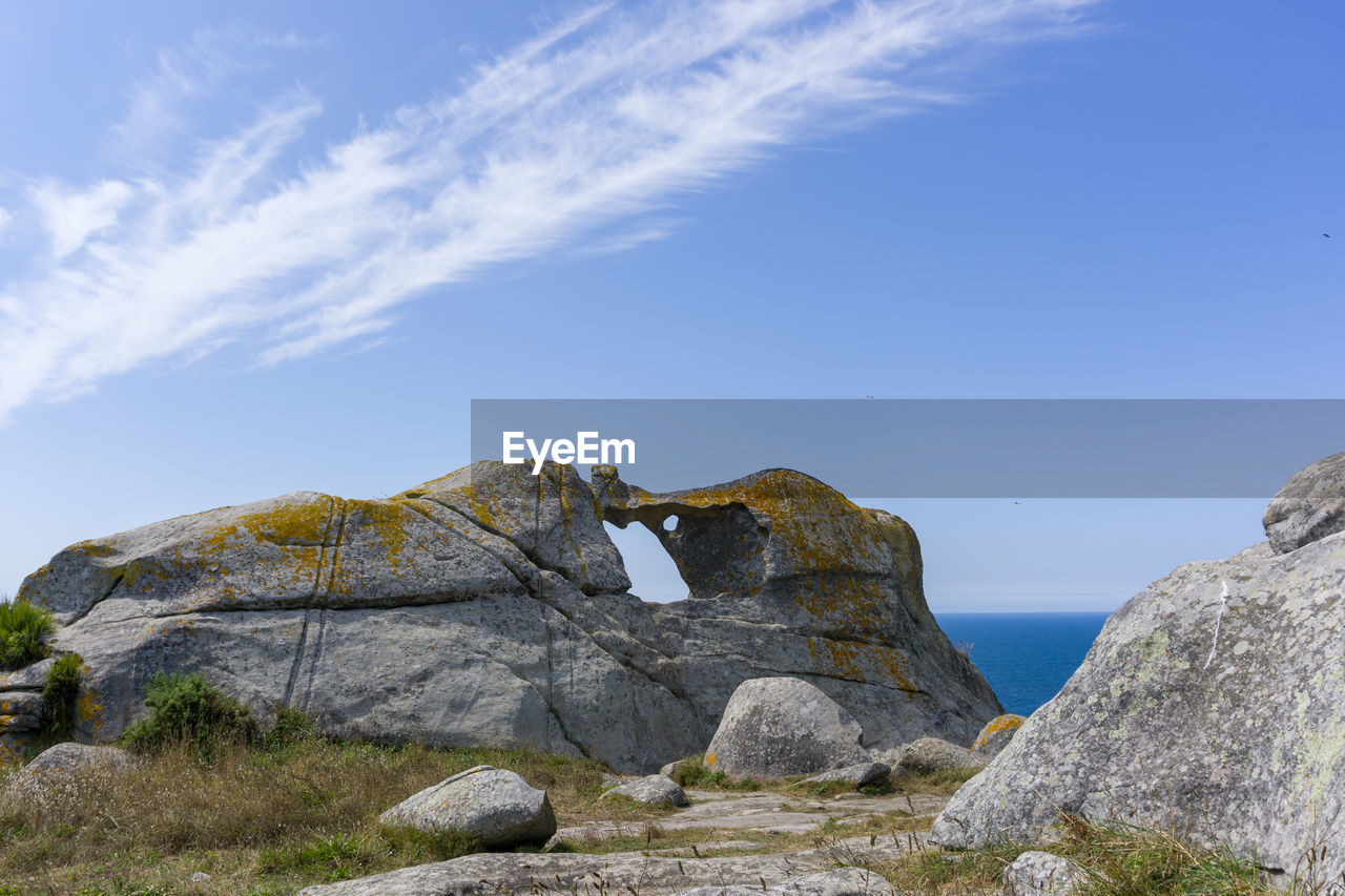 Low angle view of rock formation against sky, pedra da campá, in cíes islands 