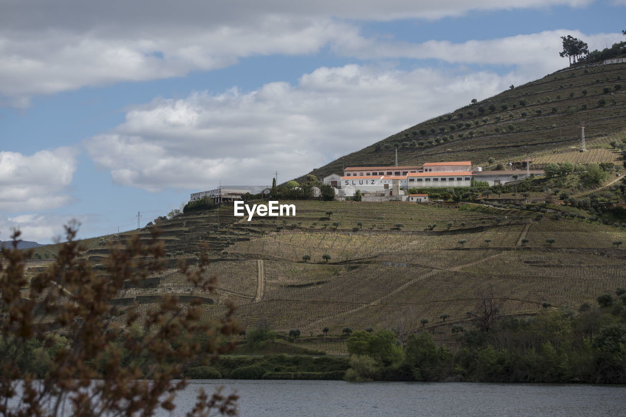 BUILDINGS ON MOUNTAIN AGAINST SKY