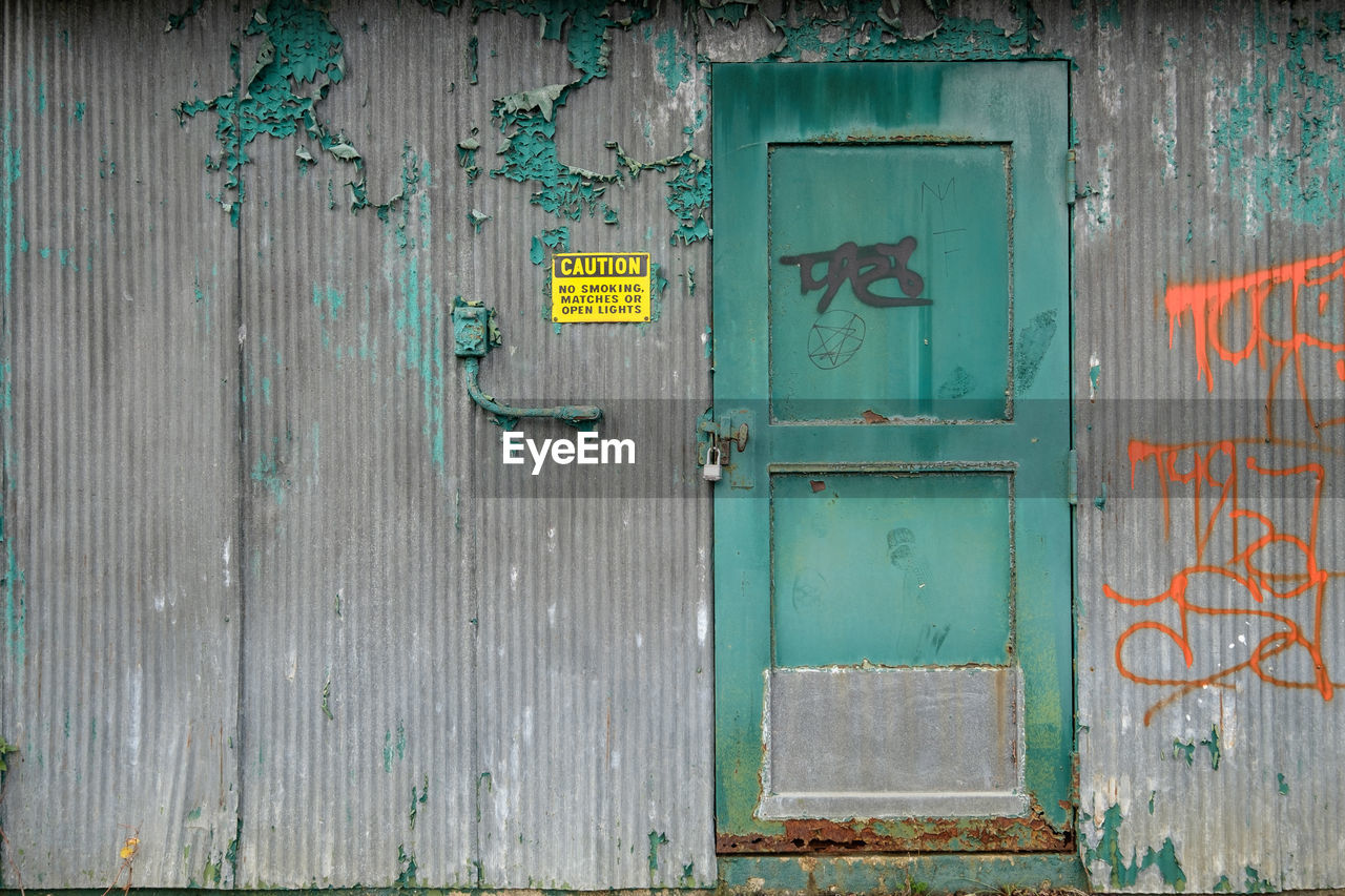 CLOSED DOOR OF BUILDING WITH GRAFFITI