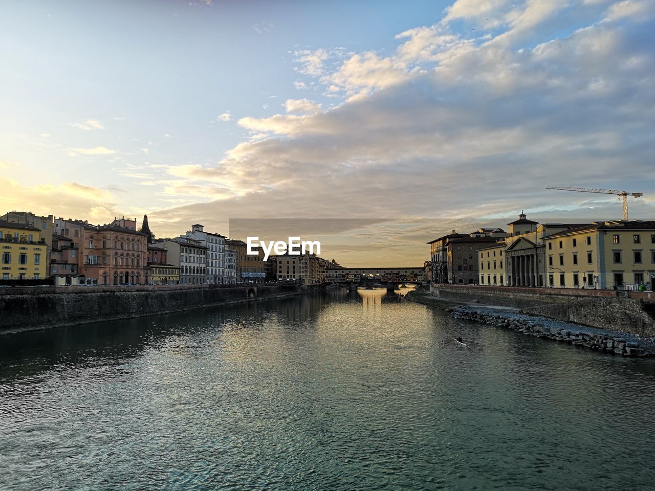 BUILDINGS BY RIVER AGAINST SKY