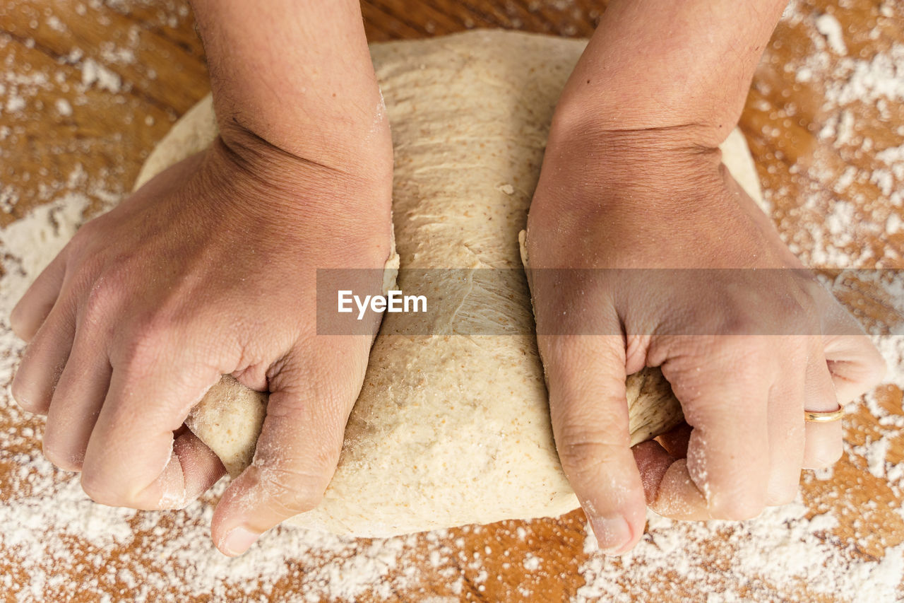 HIGH ANGLE VIEW OF HUMAN HAND HOLDING BREAD