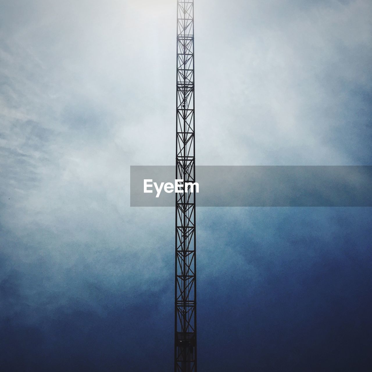 Directly below shot of crane against cloudy sky