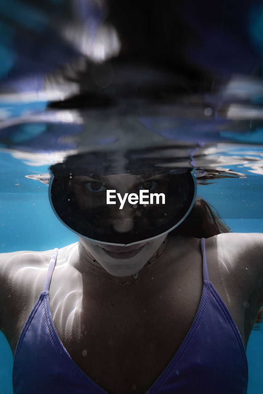 Portrait of a young girl underwater with diving goggles