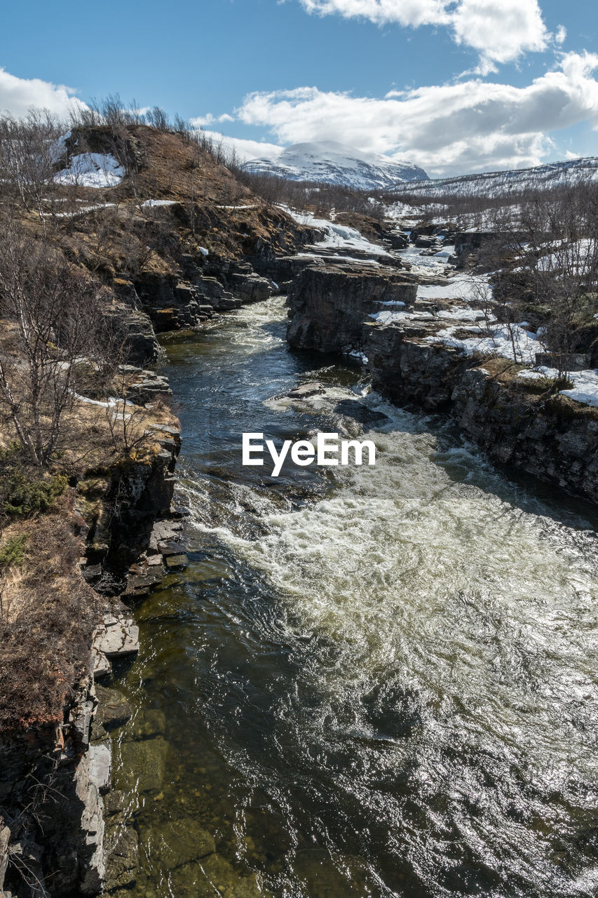 River amidst mountains against sky