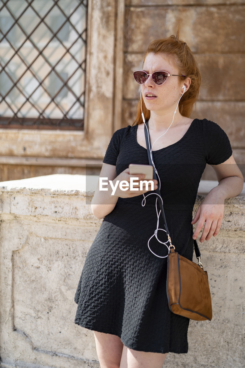 Gold hair girl listening music with smartphone using white earphones