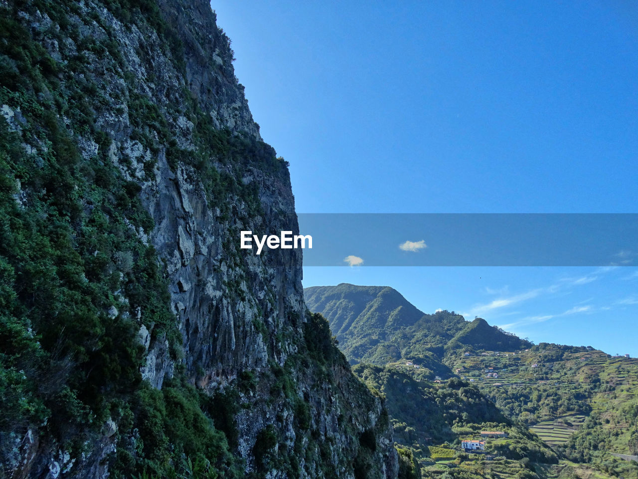 Low angle view of rocky mountains against blue sky