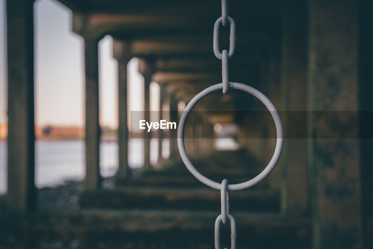 Chain hanging in bridge by river