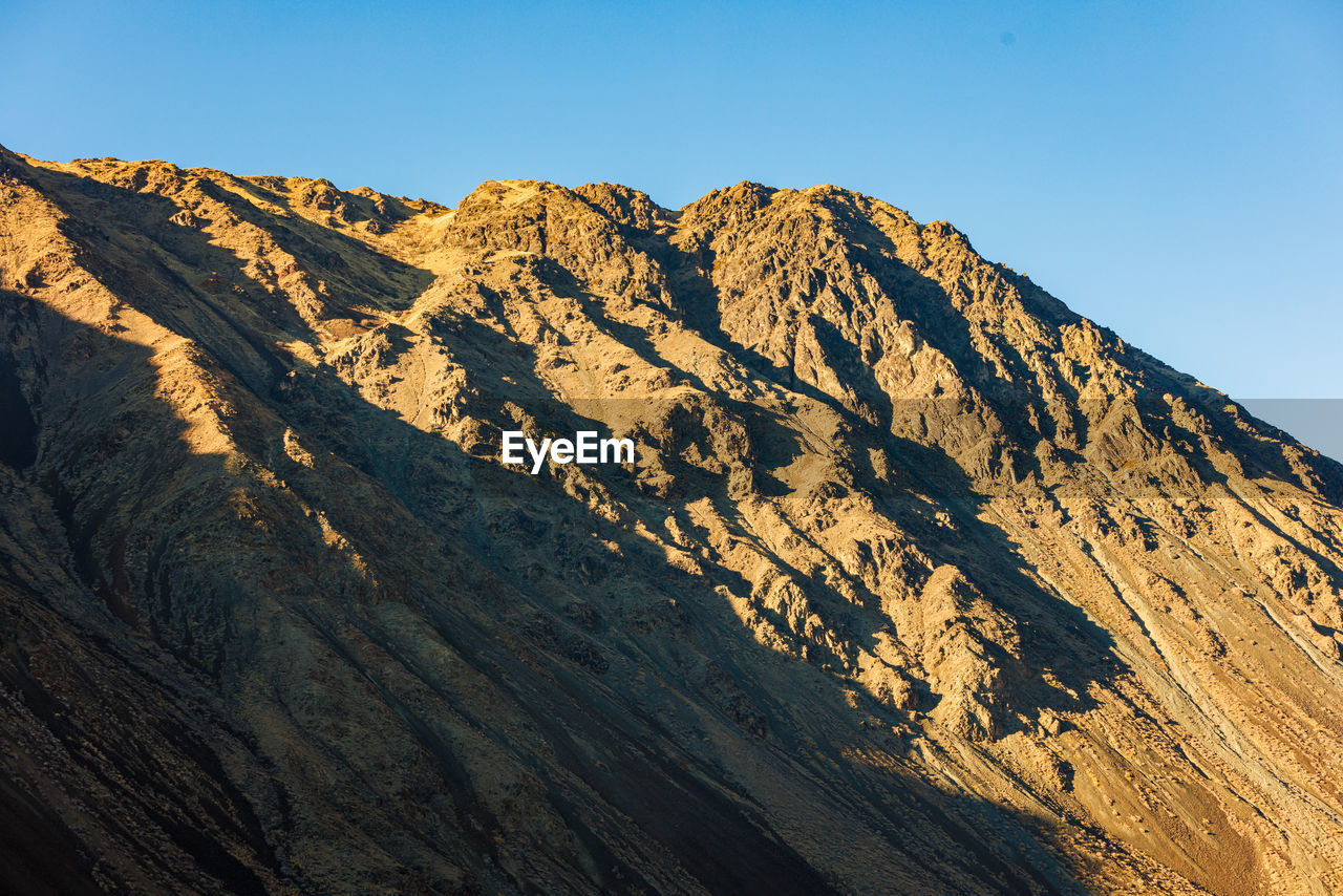 scenic view of rocky mountains against clear blue sky