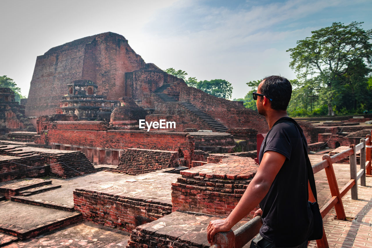 Man posing at red bricks background of nalanada ruins