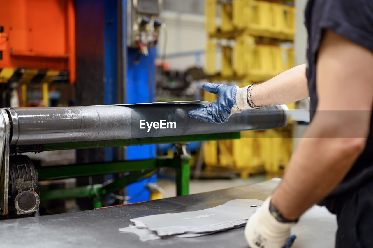 Midsection of man working in factory