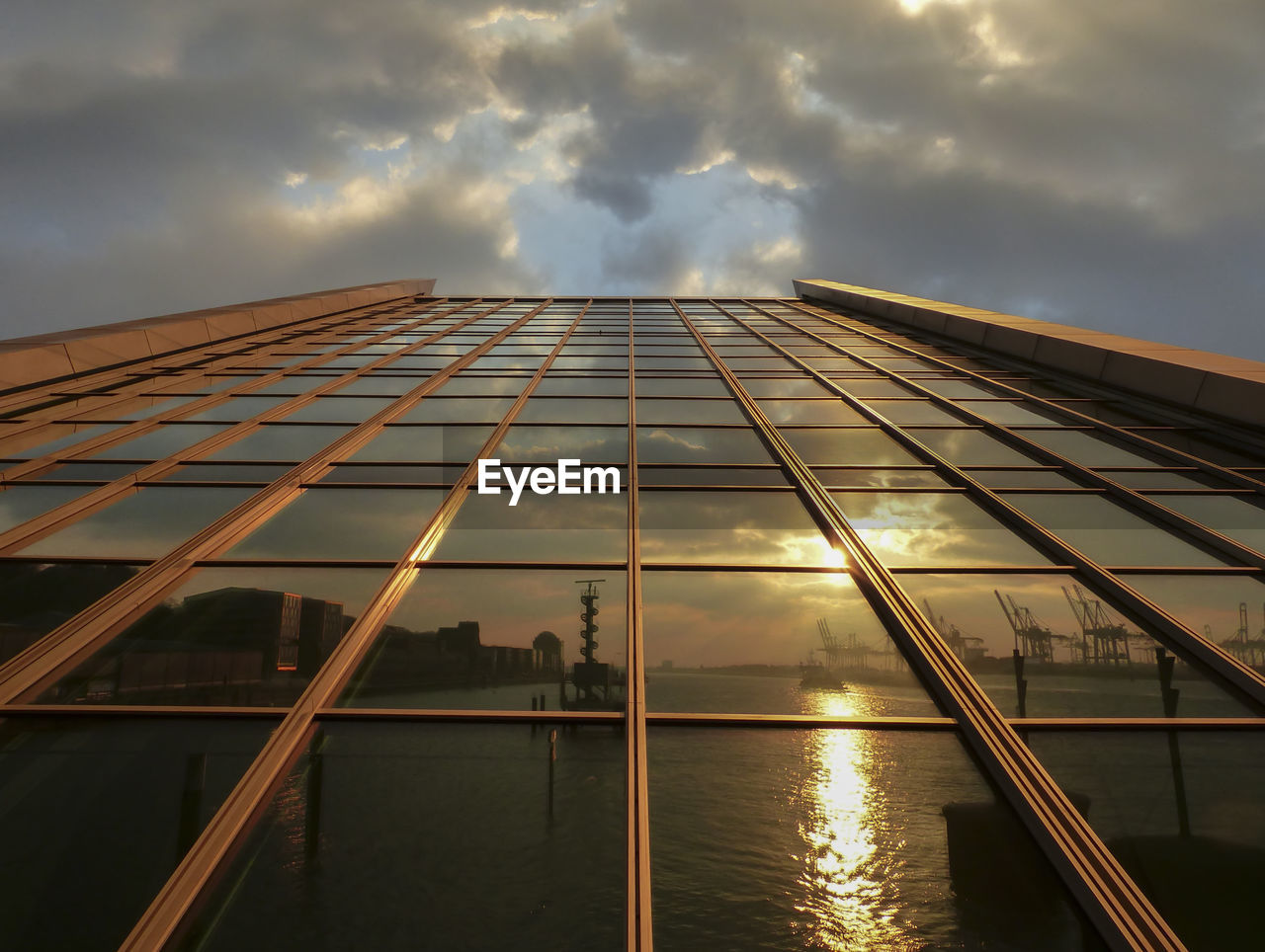 Low angle view of modern building against cloudy sky