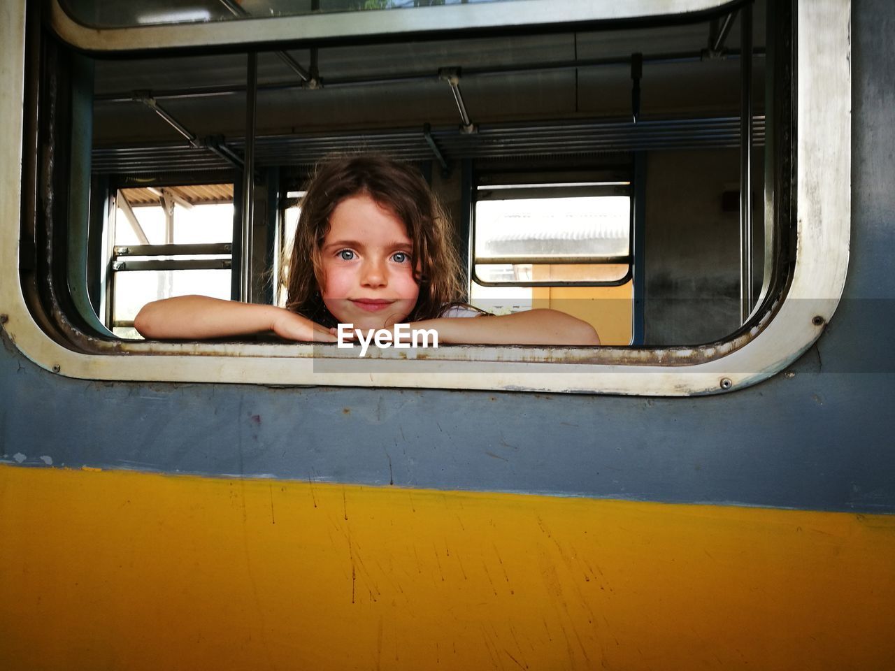 Portrait of girl looking through train's window