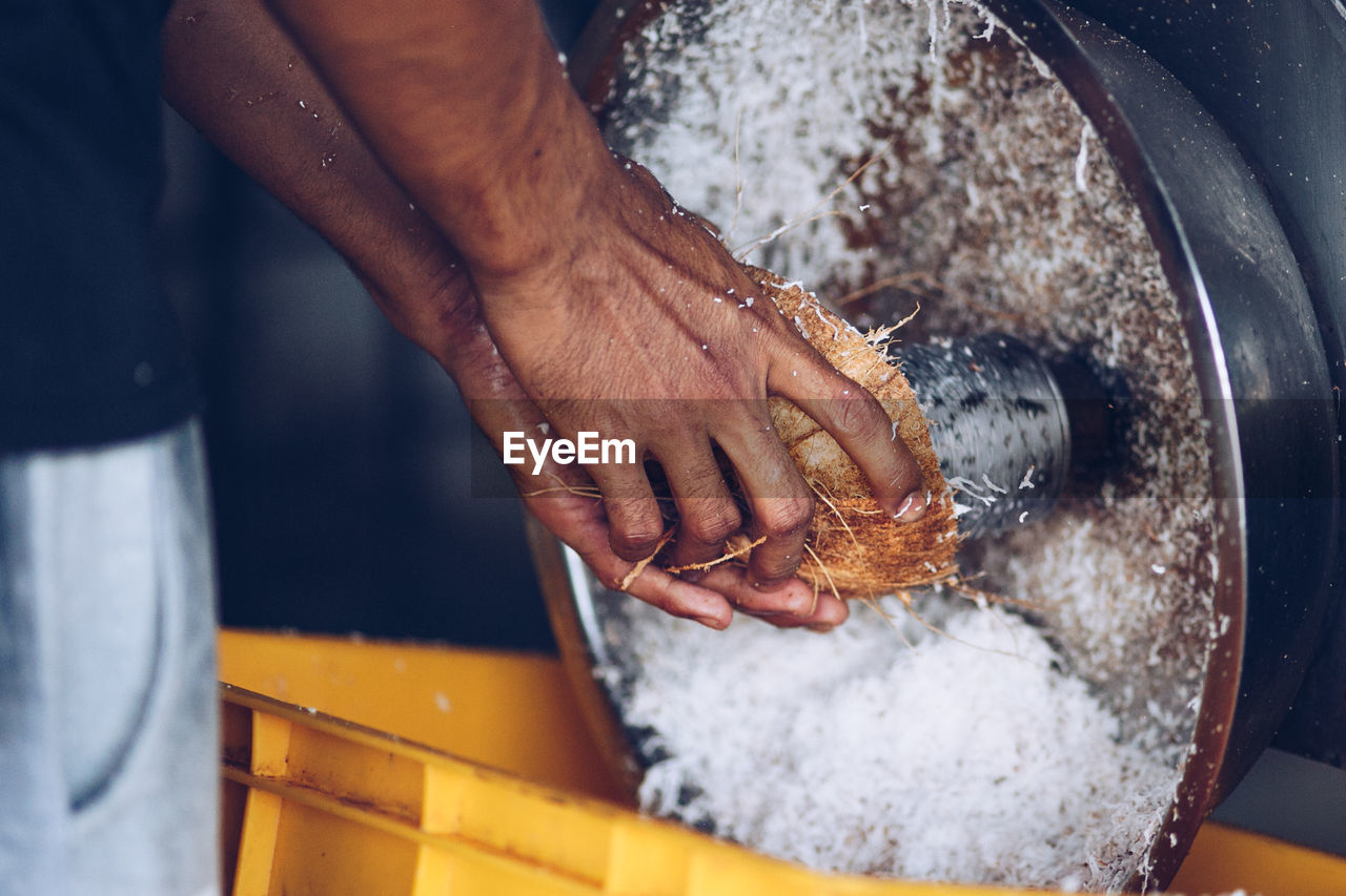 Close-up of human hand shredding coconut