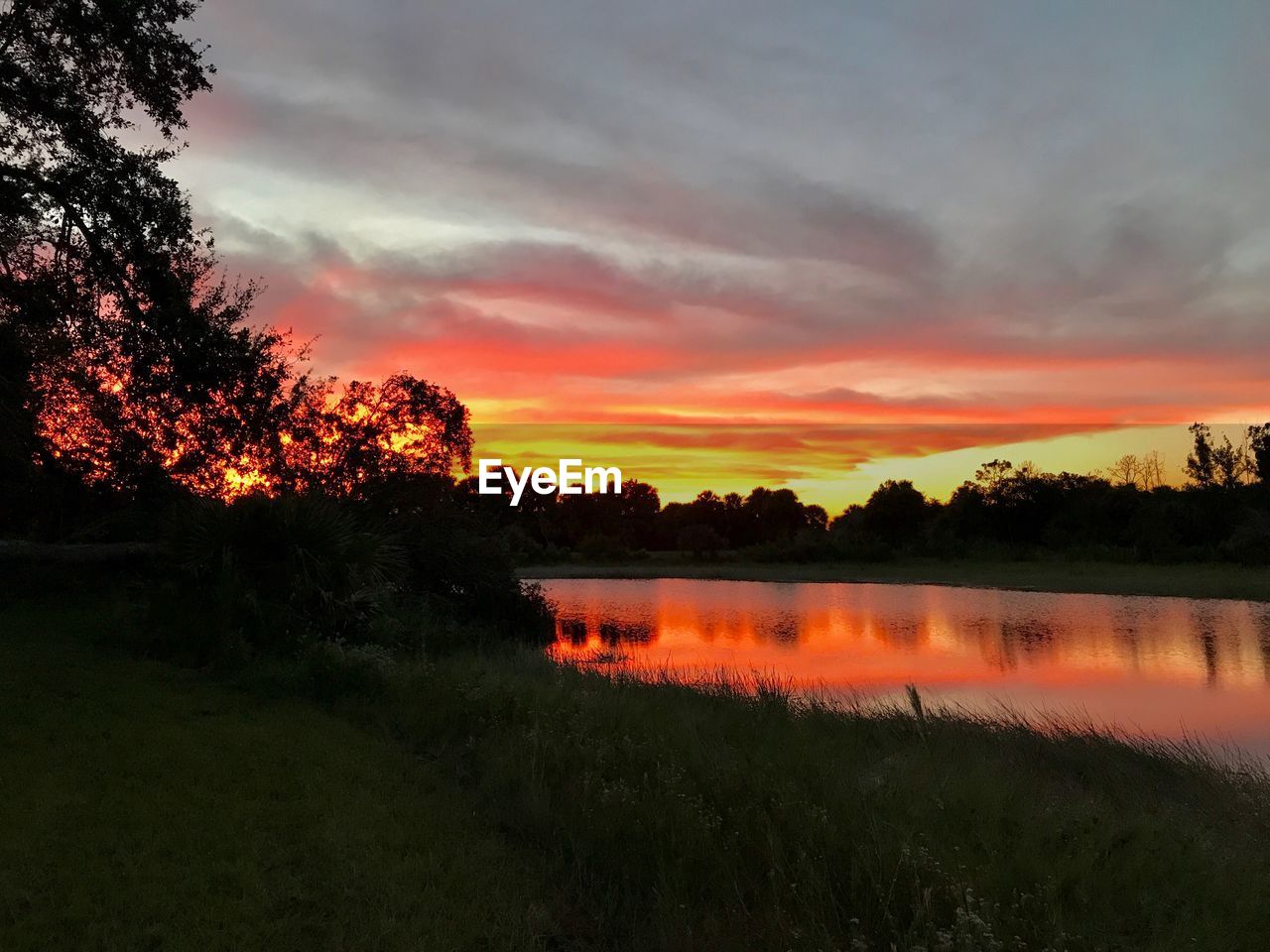 SCENIC VIEW OF LAKE AGAINST SKY DURING SUNSET