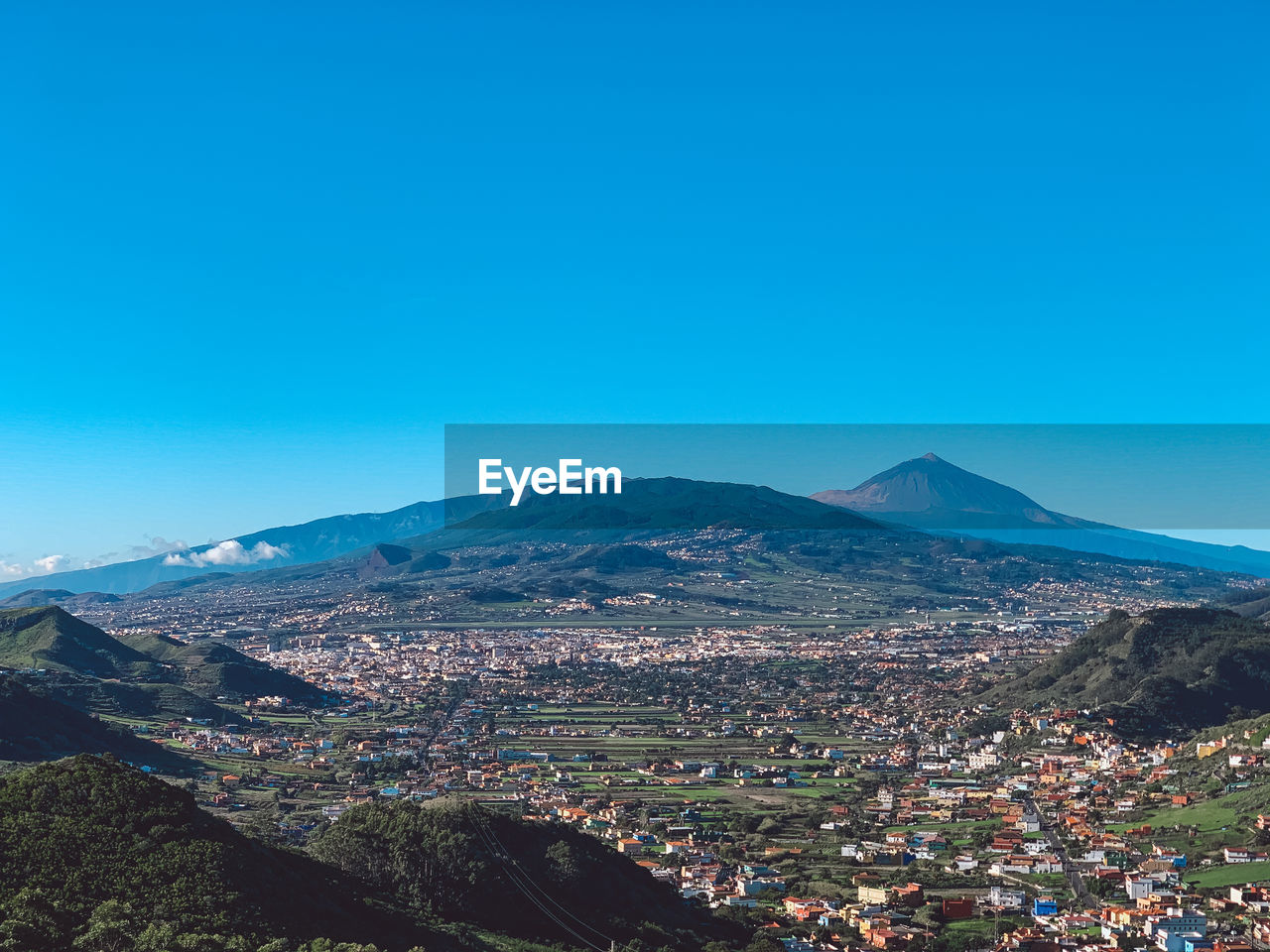 Aerial view of cityscape against clear blue sky