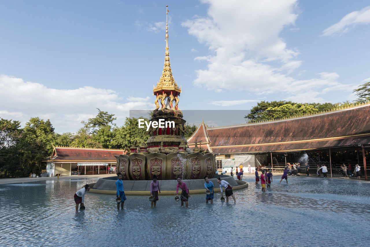 GROUP OF PEOPLE IN TEMPLE AGAINST BUILDING