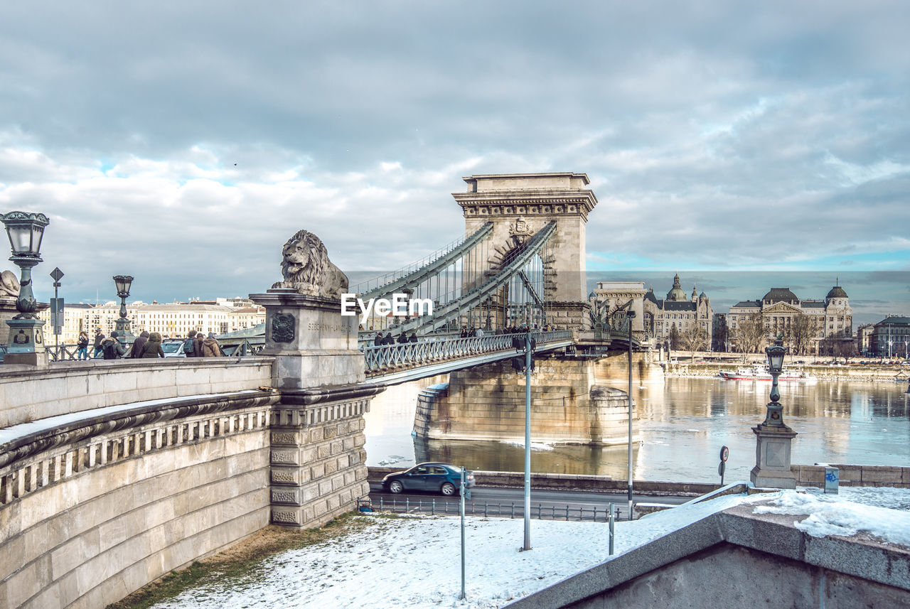 Chain bridge against cloudy sky