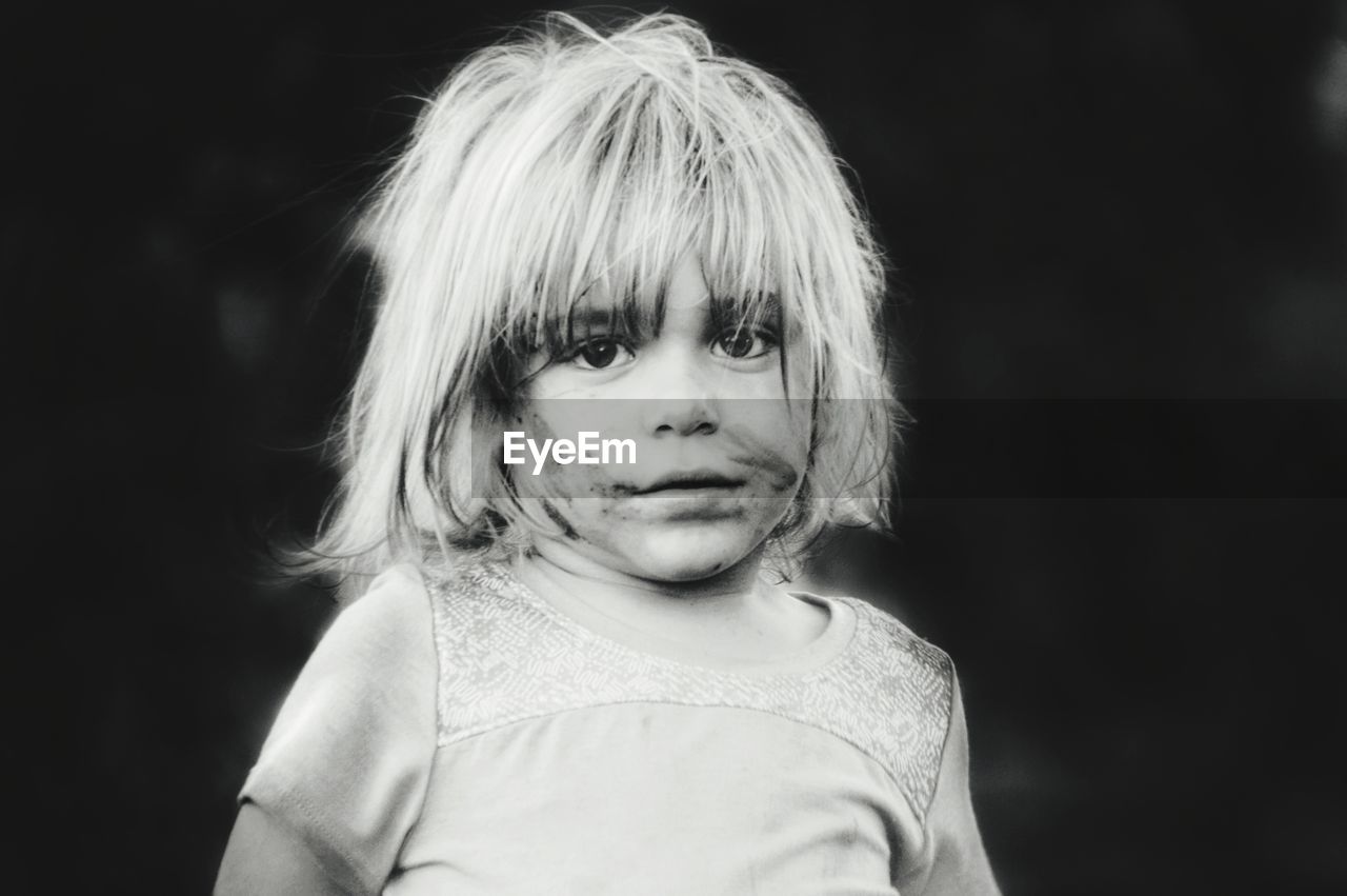 Portrait of cute boy against black background