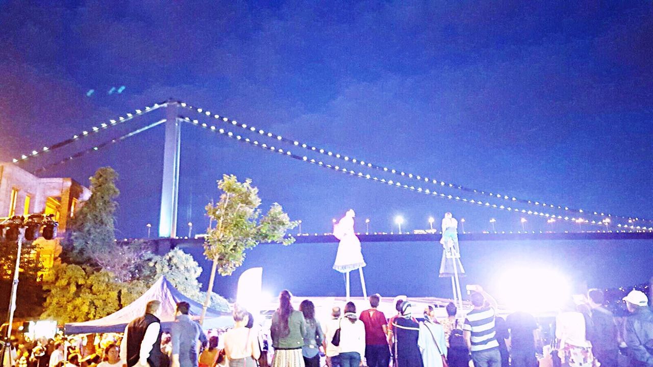 PEOPLE IN FRONT OF BUILDING AGAINST CLEAR SKY