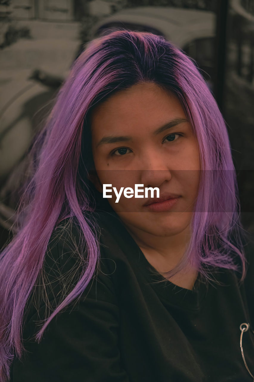 Purple hair asian woman looking straight to the camera
